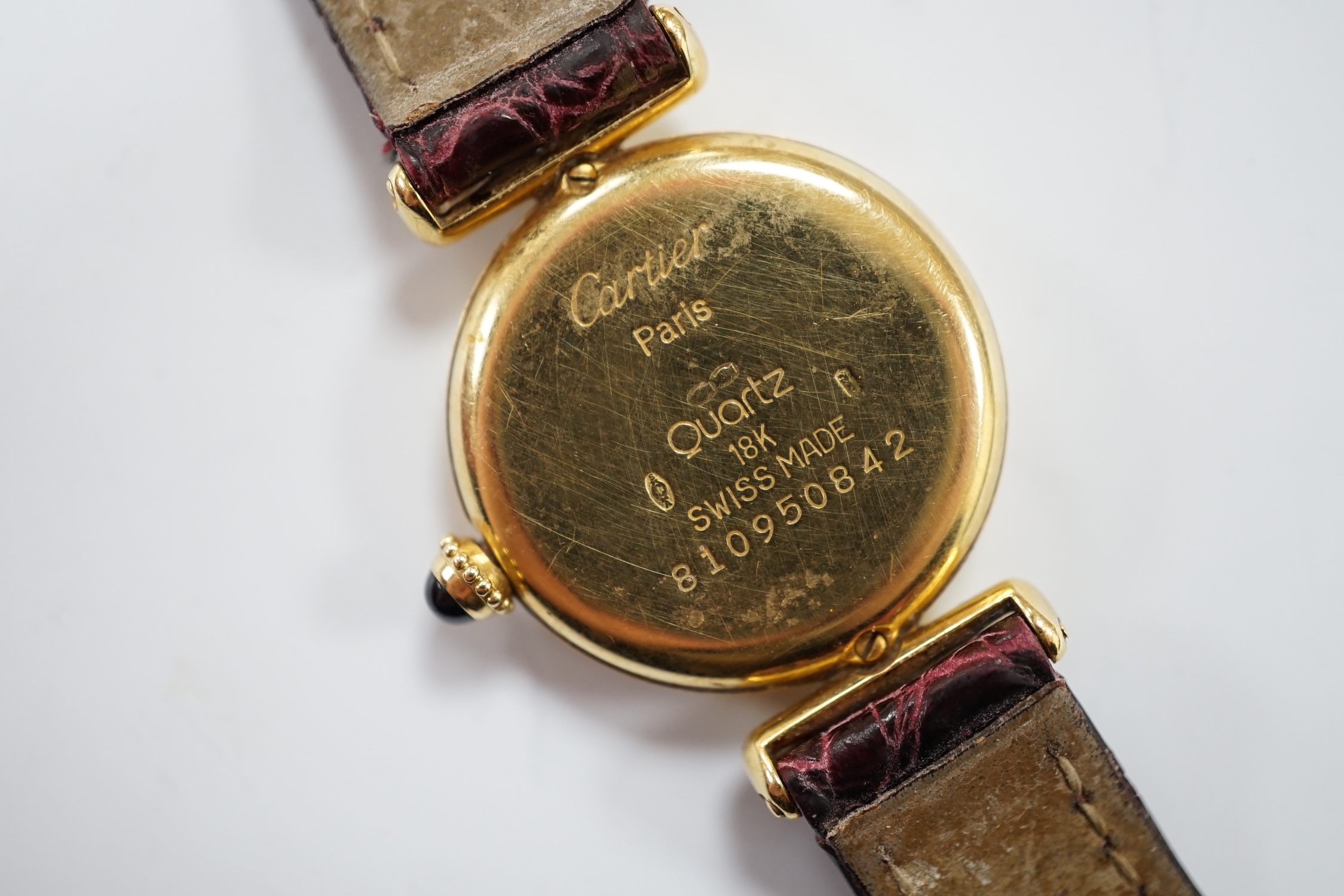 A lady's Cartier 18k Rivoli quartz wrist watch, with circular Roman dial and Cartier pouch and certificate dated 1987.